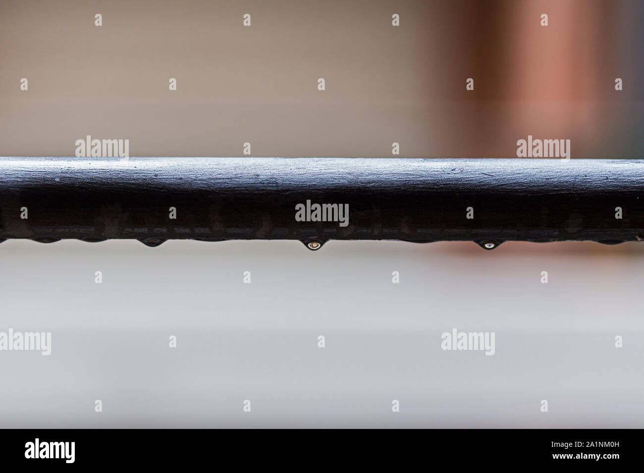 Rain water drops falling on a dark tube Stock Photo