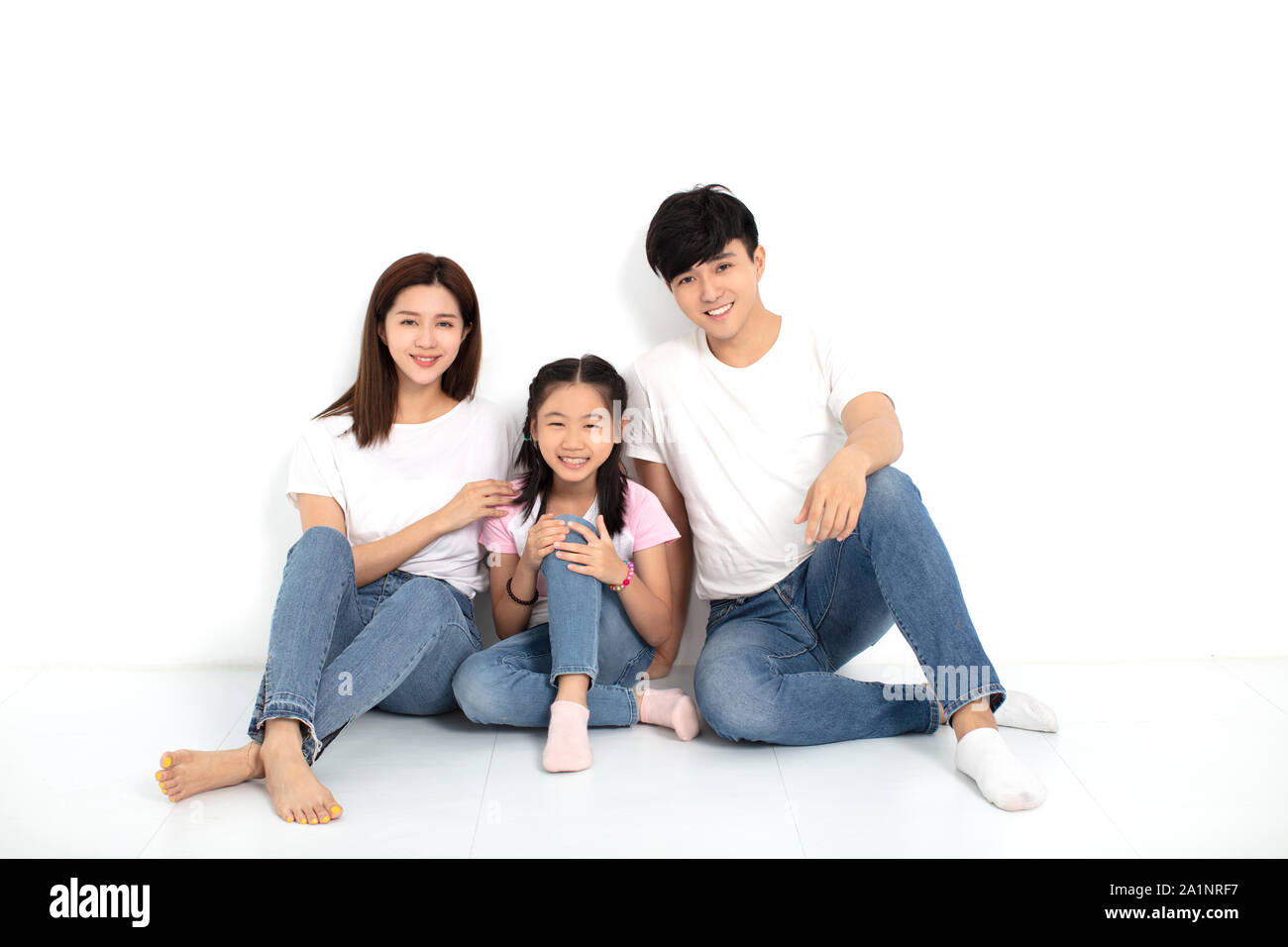 Happy asian Young family Sitting On Floor Stock Photo