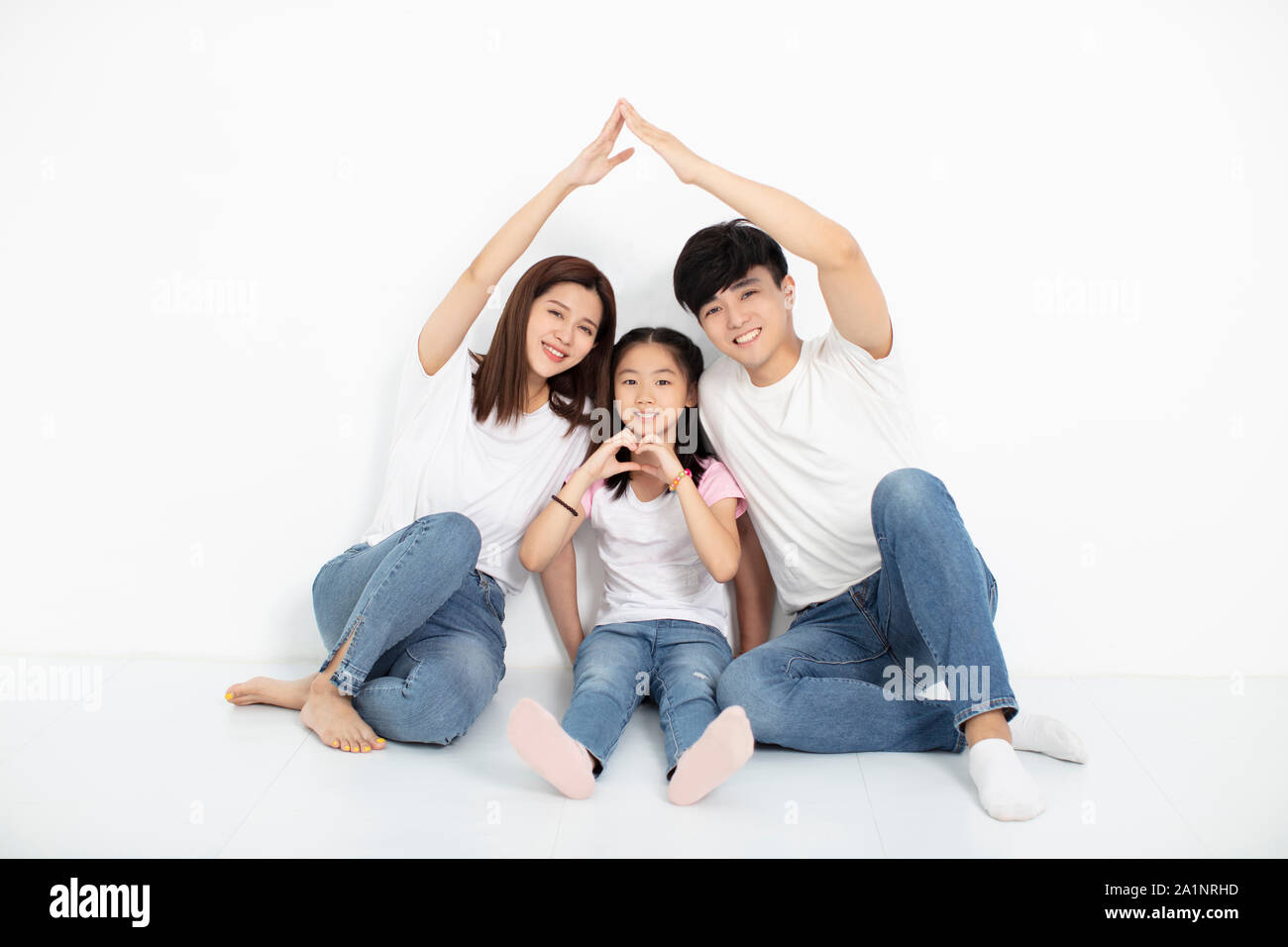 happy young family sitting on floor with home concept Stock Photo