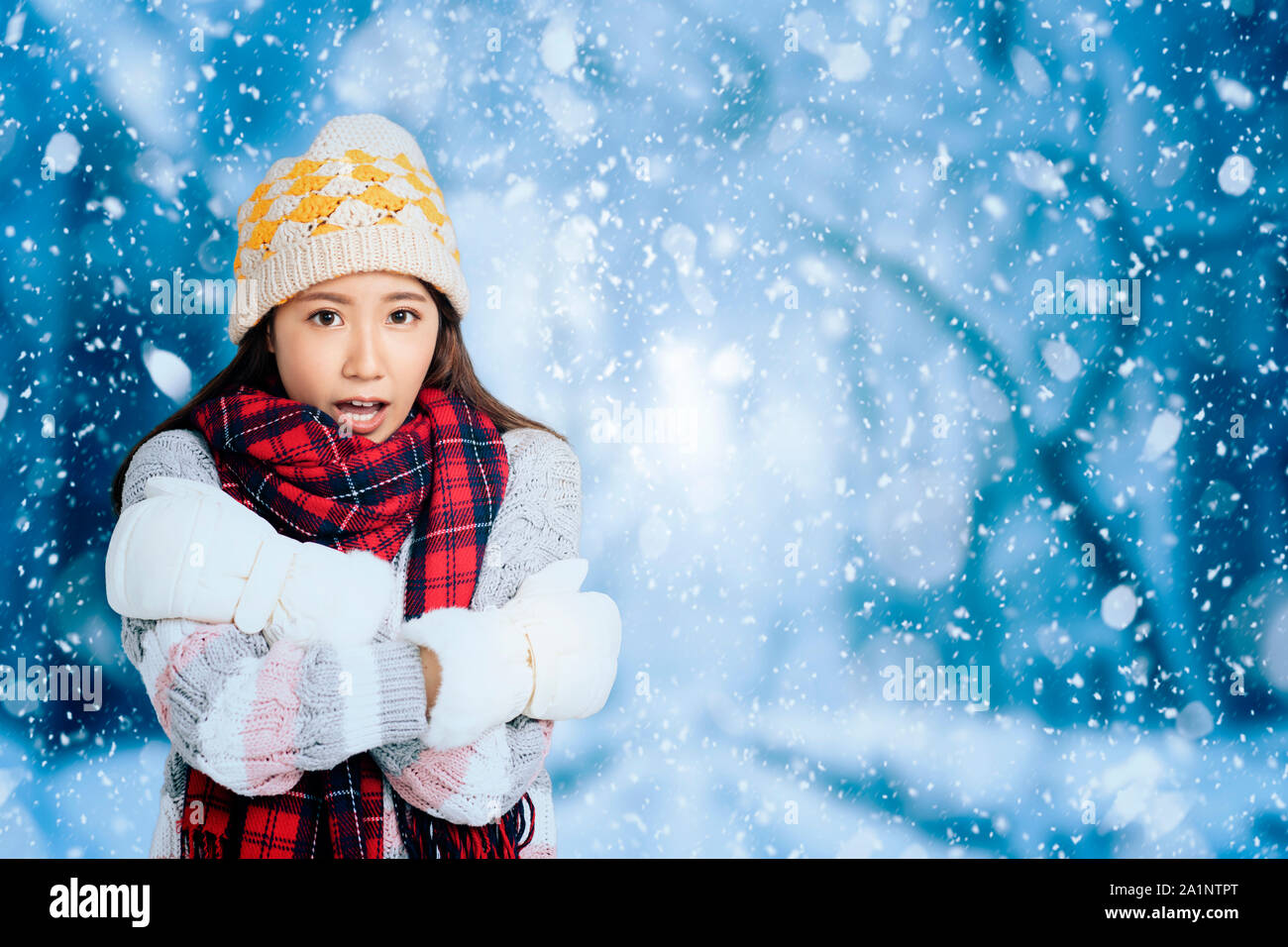 Young Beautiful Woman in winter clothes with snow background Stock Photo