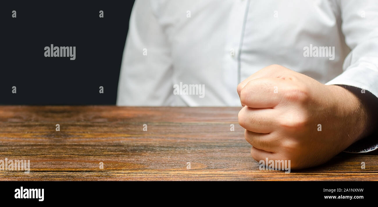 The man hit slammed his fist on the table. The end of patience. It is impossible to bear it. An attack of anger, stress. A decisive, emotional gesture Stock Photo