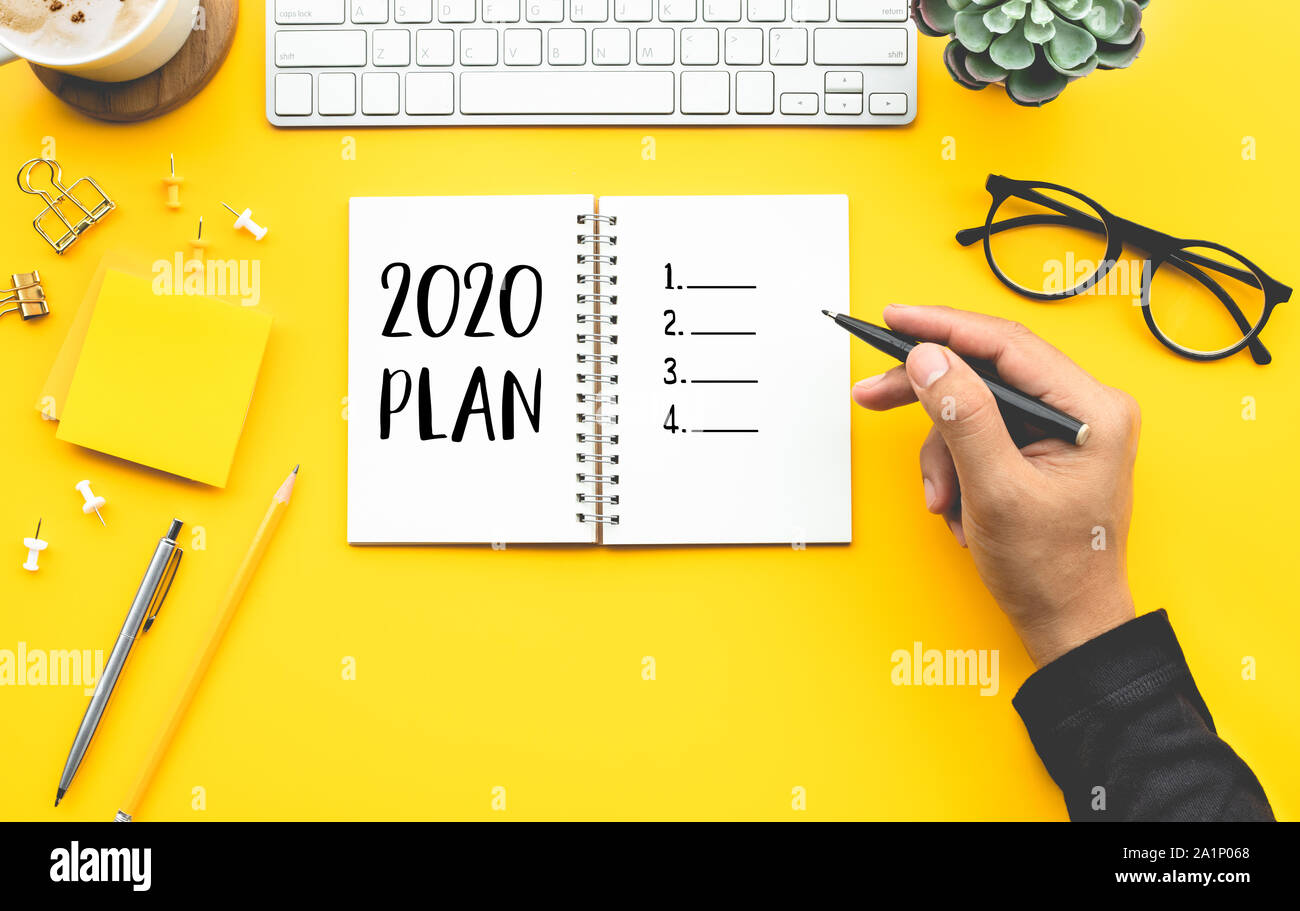 2020 plan concepts with youngman writing checklist on notepad on color desk table.Goal-plan-action and resolution concepts ideas Stock Photo