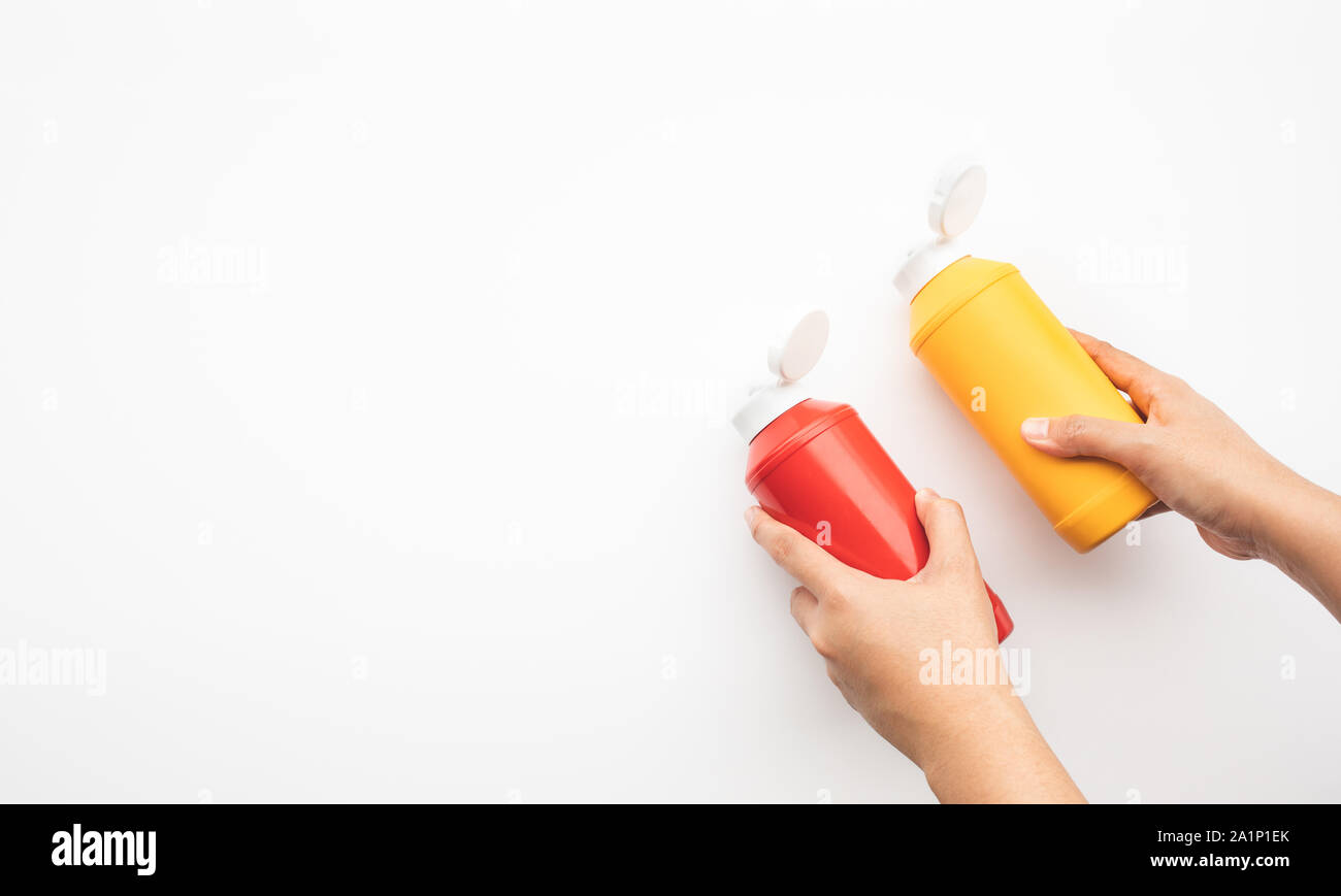 Youngwoman squeezing bottles sauce ( mustard,ketchup) for dipping on
