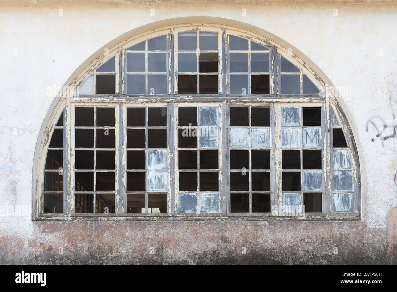 A semi circular window with lots of missing panes. Stock Photo