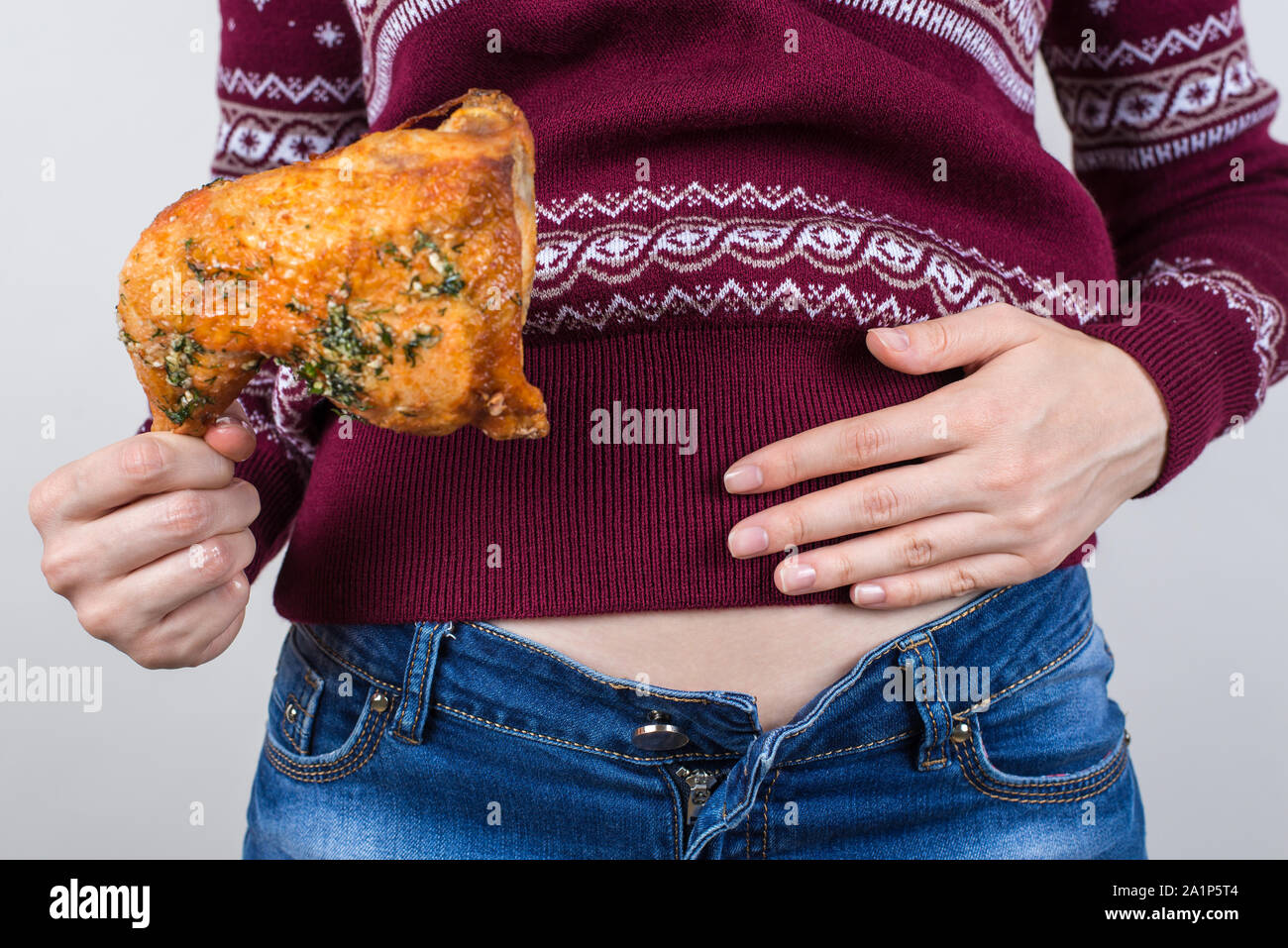 Junk food eating too much concept. Cropped close up photo of girl holding  hands palm on big full abdomen feeling heartburn after fatty greasy  nutritio Stock Photo - Alamy