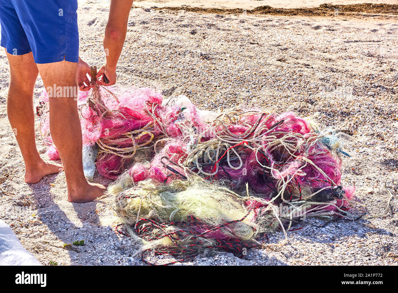 A tangled mess of fishing nets plastic rope and other debris washed up on a coastal beach. Save the Planet stock picture. Stock Photo