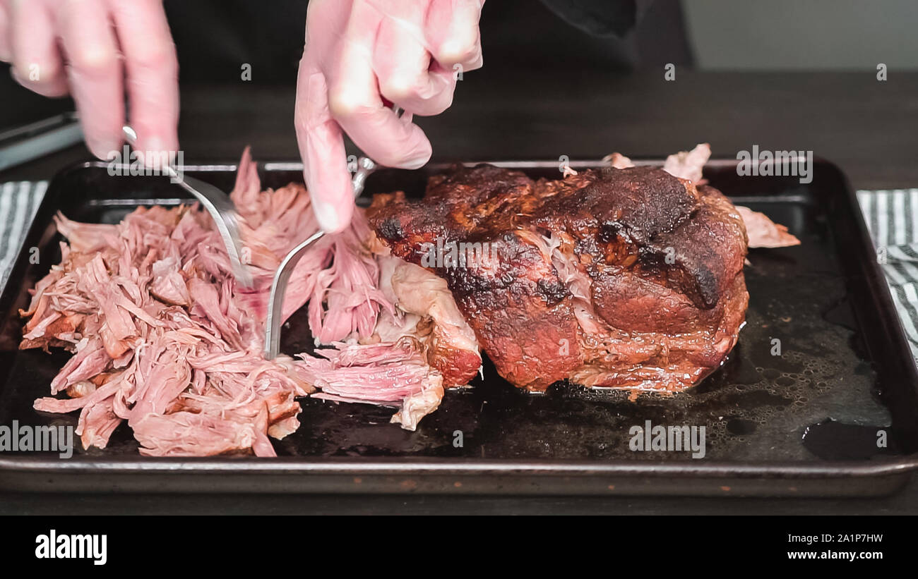 Step by step. Shredding pork roast shoulder with two forks Stock Photo