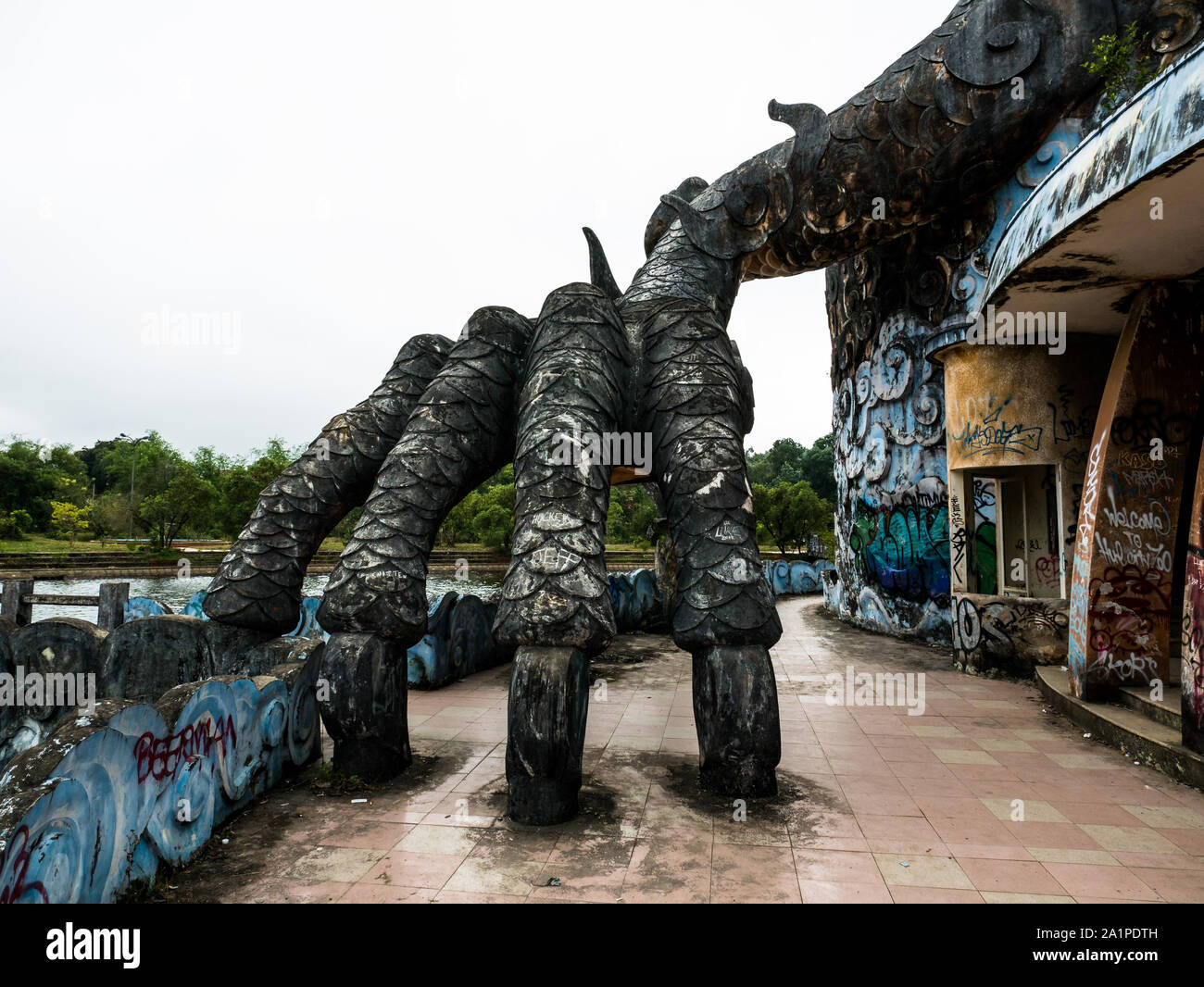 Huge and scary stone dragon foot with claws at abandoned water park, Thuy Tien lake, Hue, Vietnam Stock Photo