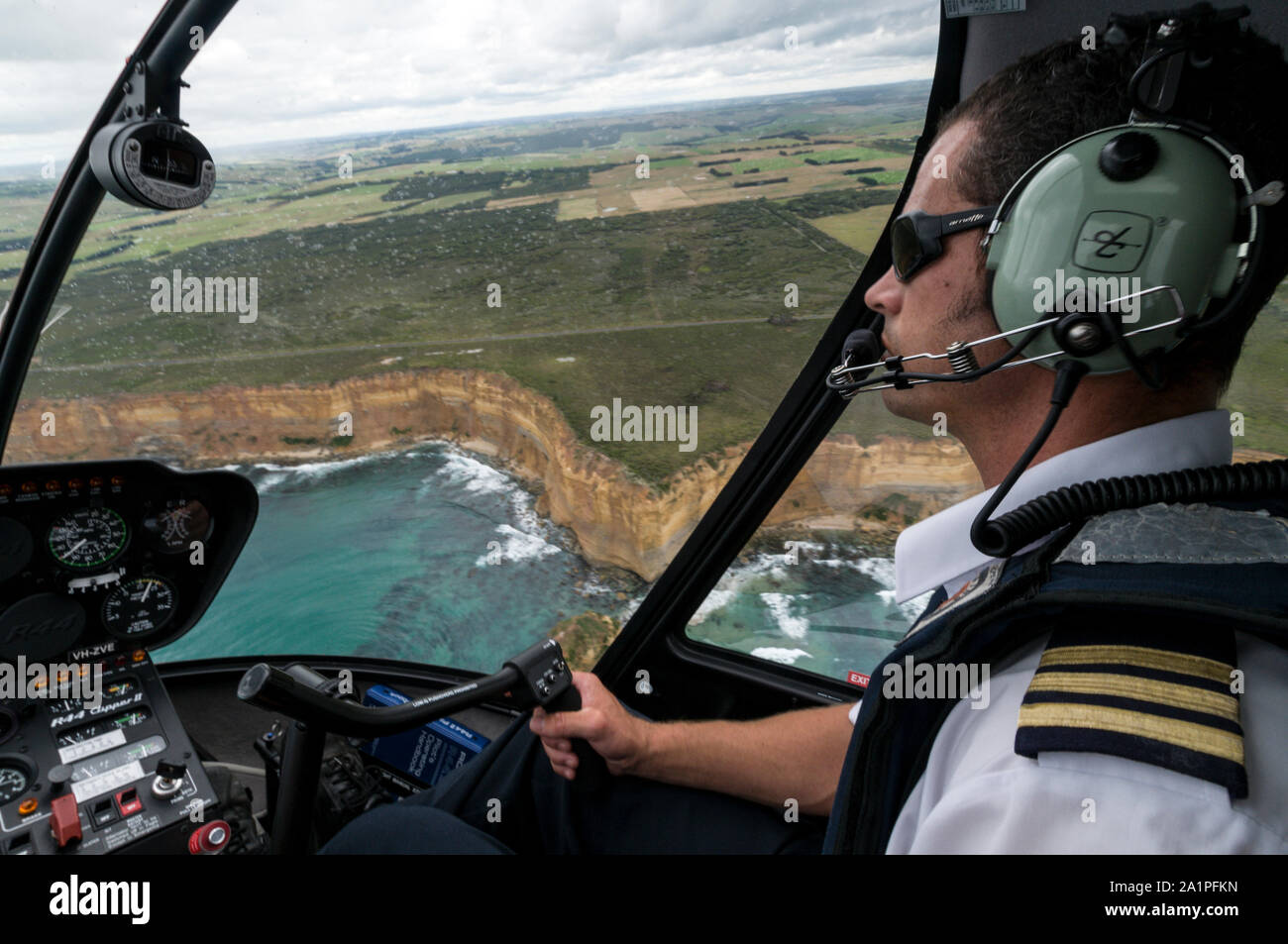 A Pilot At The Controls In A Helicopter From 12 Apostles Helicopter Flights Flies Close Over The Twelve Apostles And The Great Ocean Road Along T Stock Photo Alamy