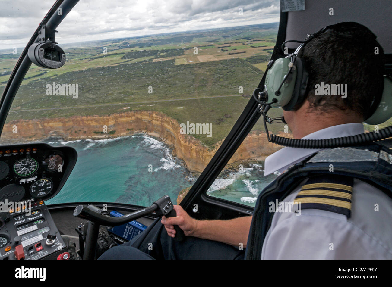 A pilot at the controls in a helicopter from '12 Apostles helicopter  flights', flies close over the 'Twelve Apostles' and the Great Ocean Road  along t Stock Photo - Alamy