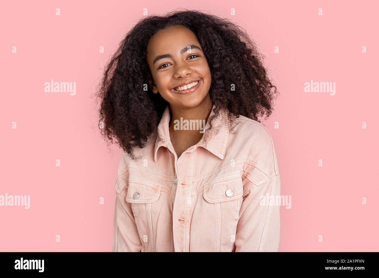 African descent girl wearing denim jacket standing isolated on pink ...