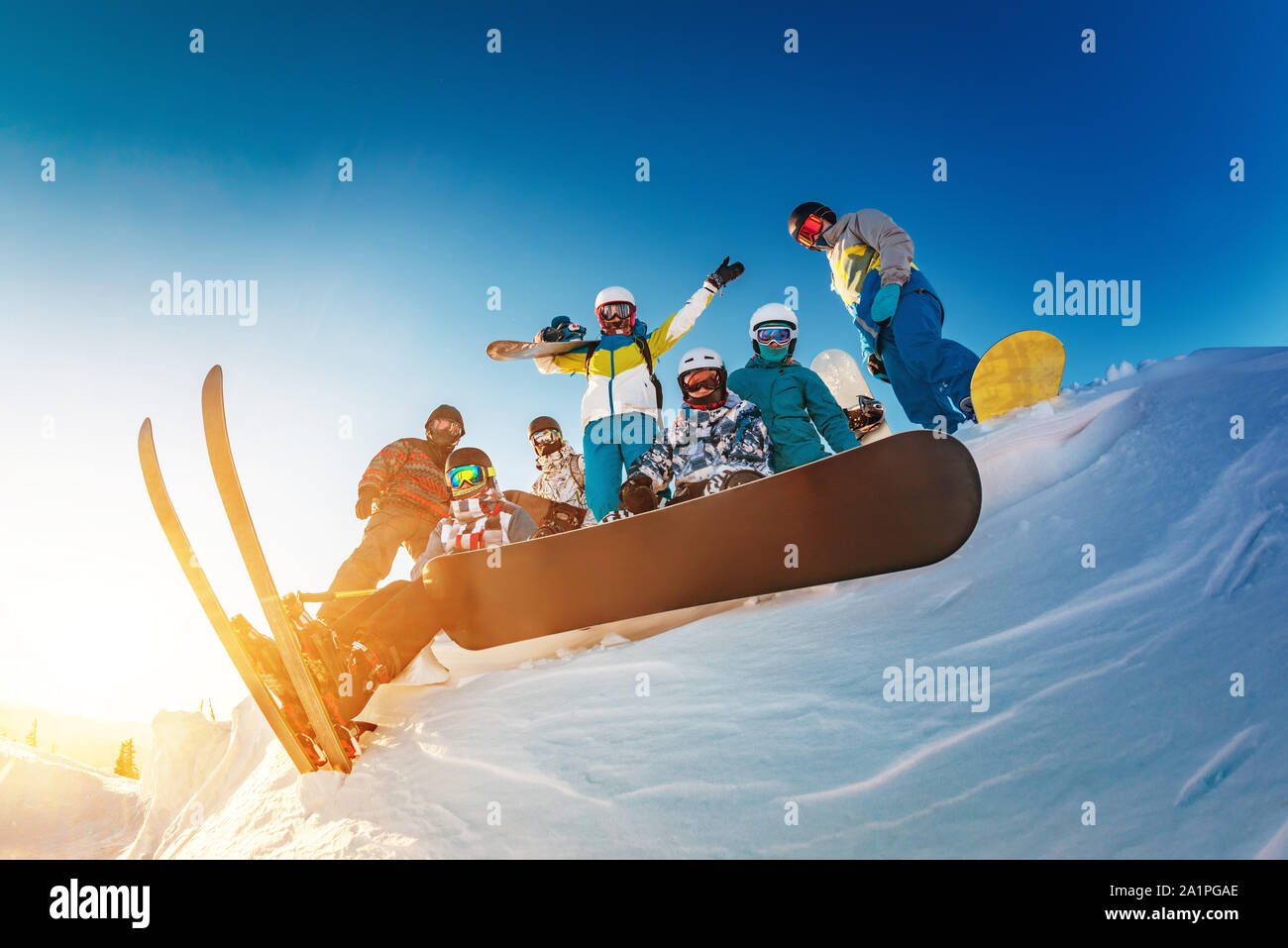 Big group of happy skiers and snowboarders are posing against blue sky Stock Photo