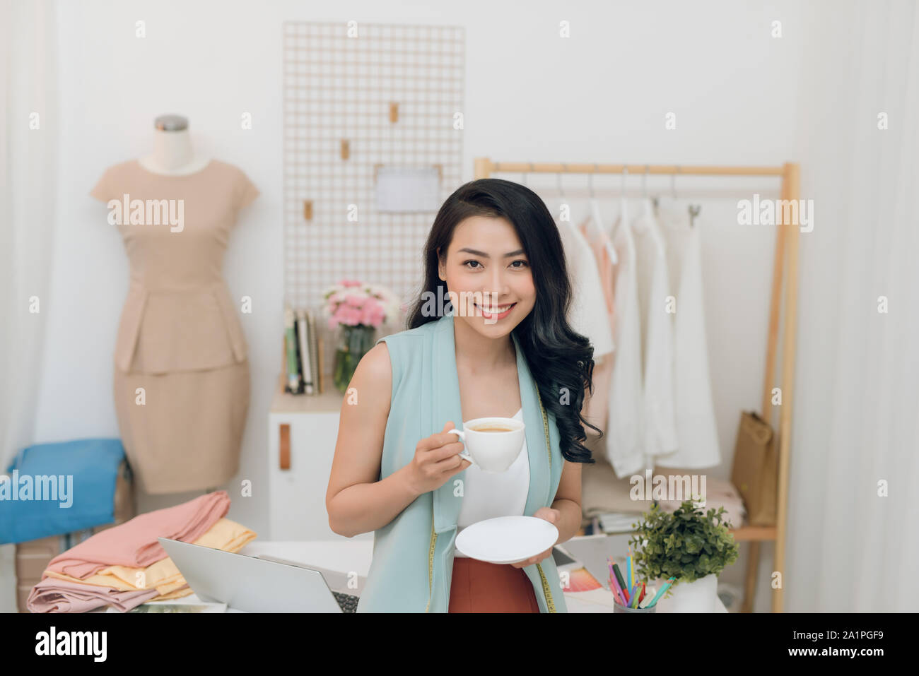 Portrait of beautiful young Asian fashion designer businesswoman at her ...
