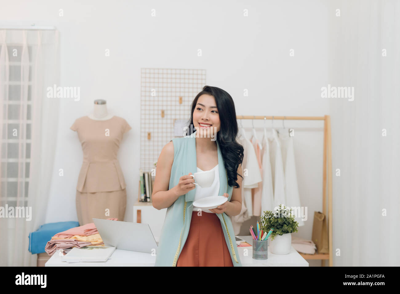 Portrait of happy Asian fashion designer businesswoman at studio ...