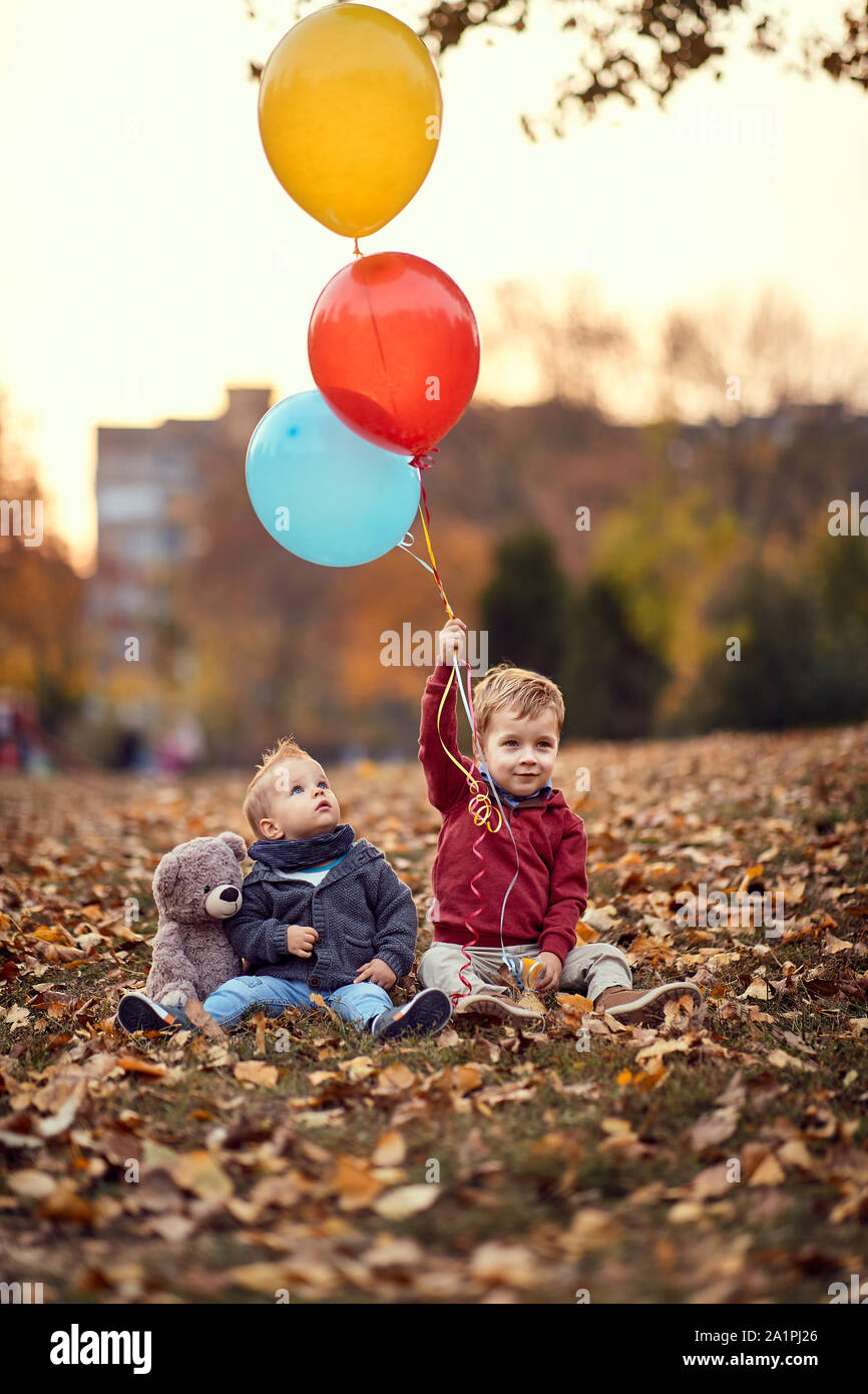 Little boy. Golden autumn. Sunny day. boys smiling boys playing with balloons in the autumn park. Stock Photo