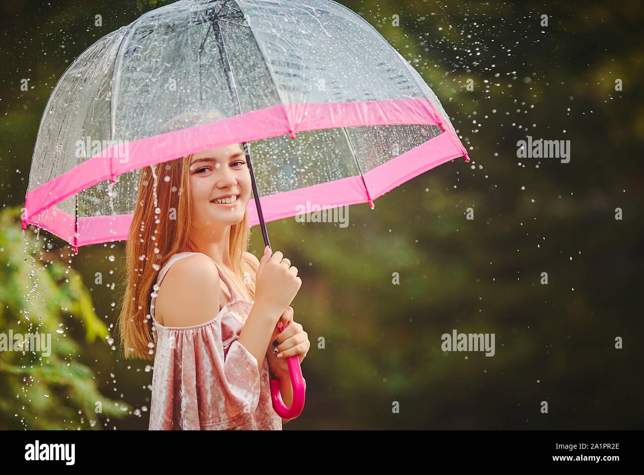 A teenage girl hid from the rain under an umbrella while walking