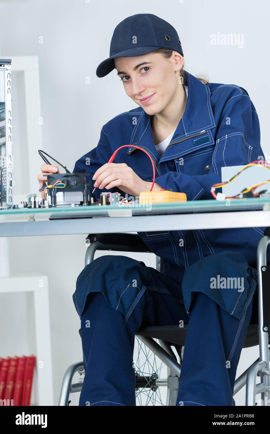 Image showcasing female electronician in wheelchair repairing computer motherboard Stock ...