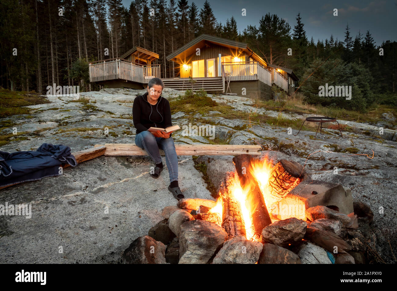 woman reading, campfire in norway Stock Photo