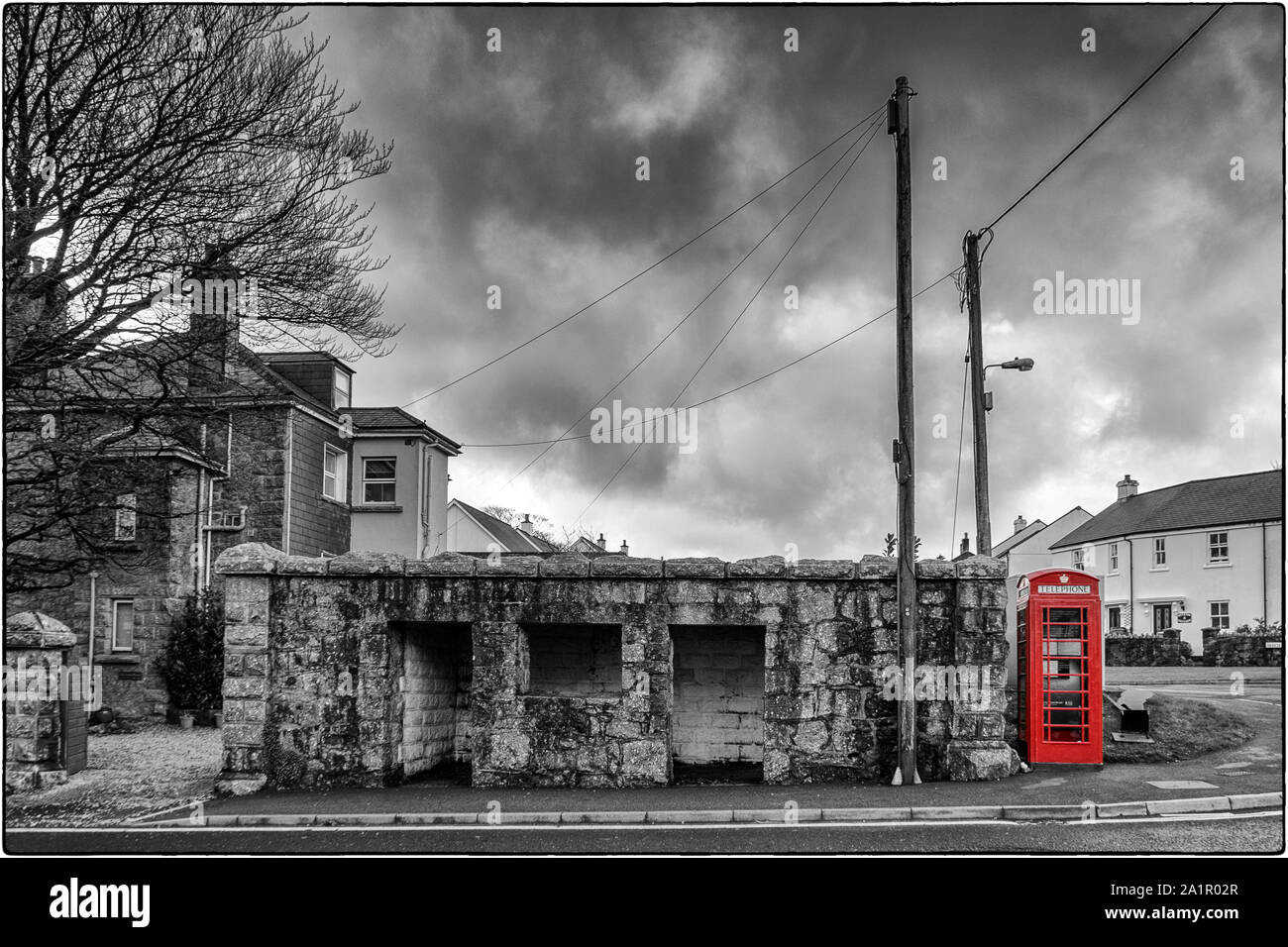Red Telephone Box in Princetown, Dartmoor, England - black & white with selective red colour Stock Photo