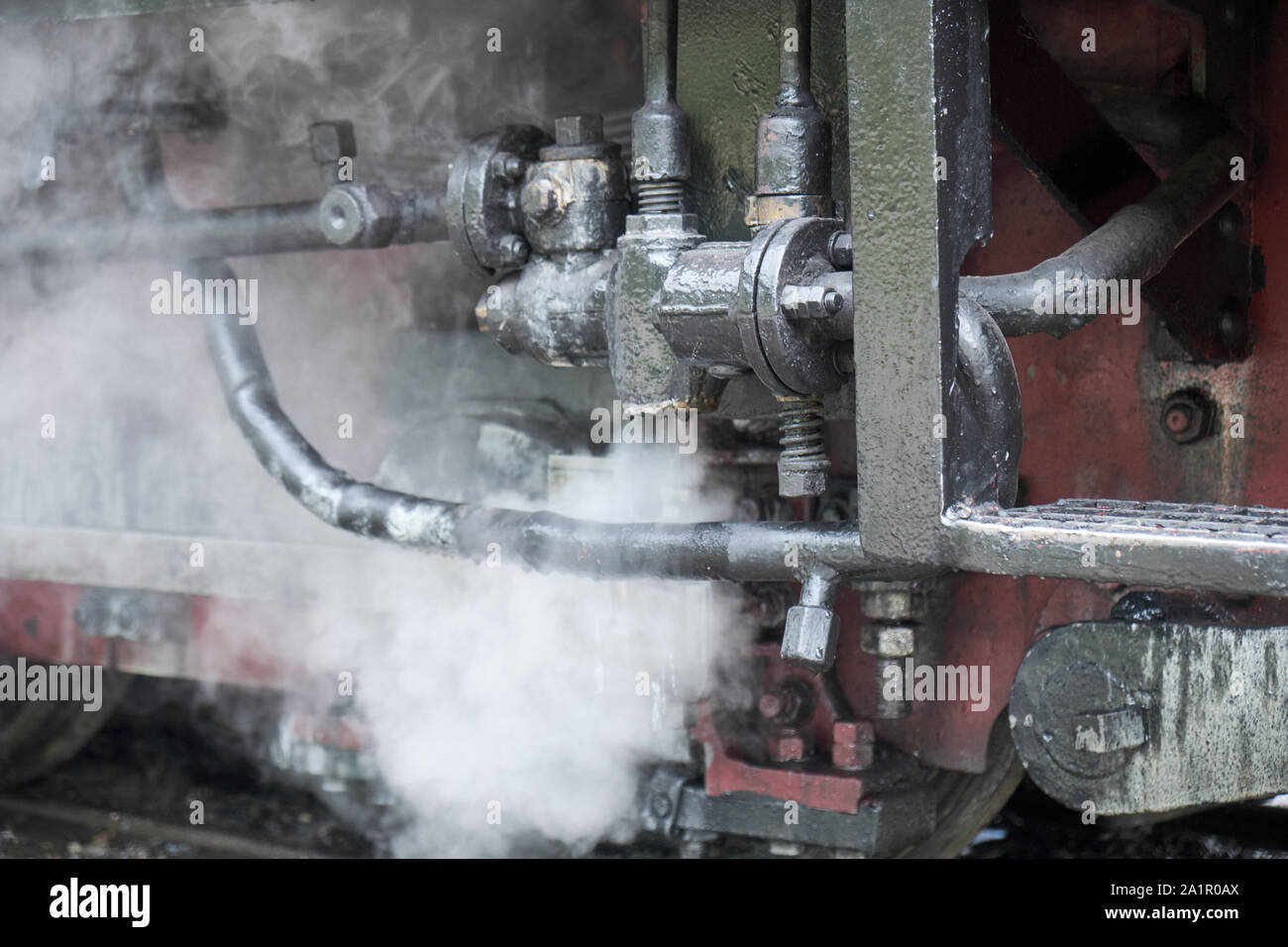 Close up of pipes of engine on old romanian steam engine train from Resita corporation. With steam coming out downwards Stock Photo