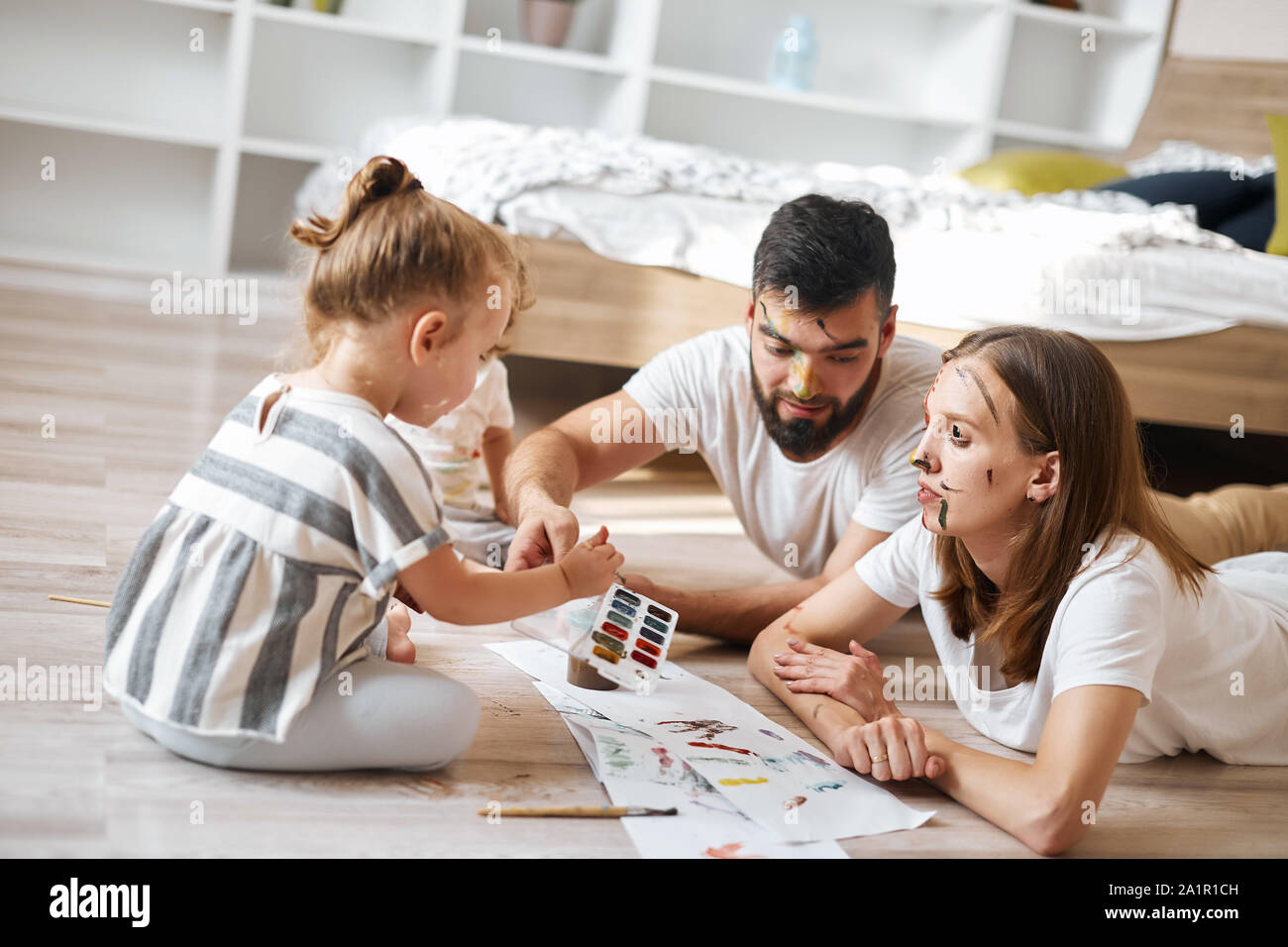 young father , mother and kids mixing colourswhile painting. close up photo Stock Photo