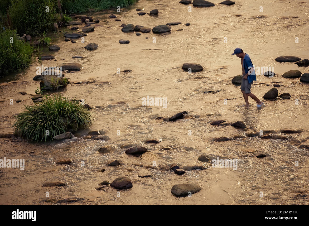Wulingyuan, China -  August 2019 : Chinese crossing shallow river at dusk Stock Photo