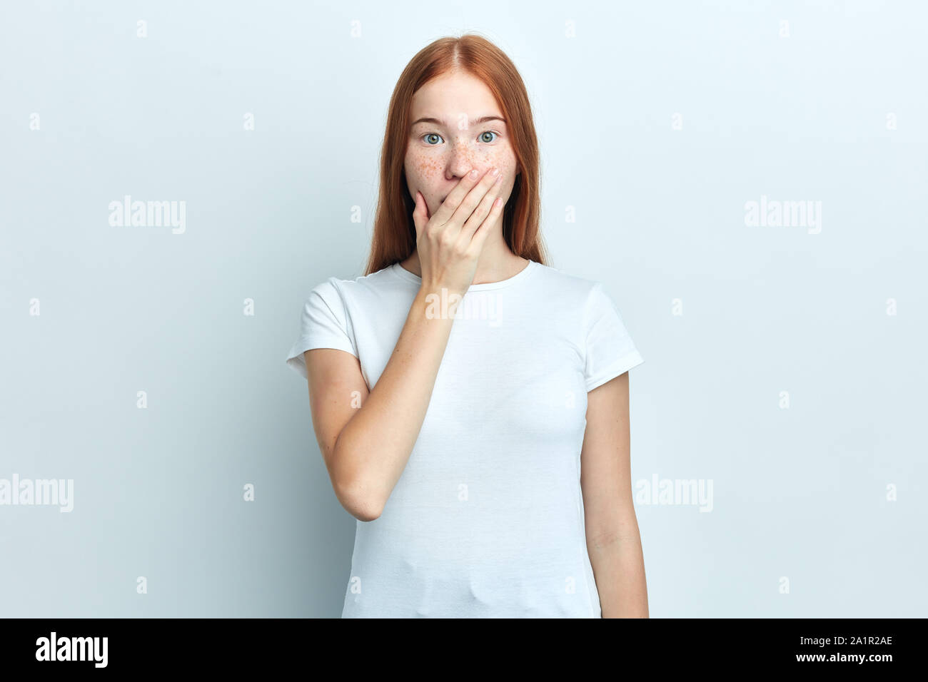 Close up portrait of upset scared hipster girl , covering her mouth with palm to prevent screaming sound, after seeing or hearing something bad. Negat Stock Photo