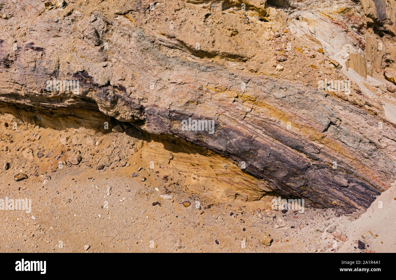 layers of soil and rock exposed by road building on in makhtesh ramon near Mitspe Ramon in Israel showing strata of various colors and textures Stock Photo