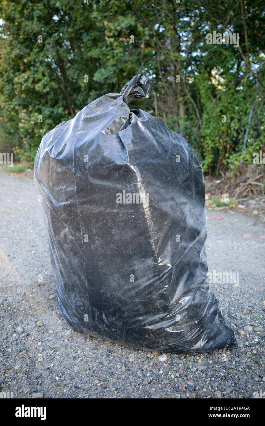 illegally disposed black bin bag in landscape Stock Photo