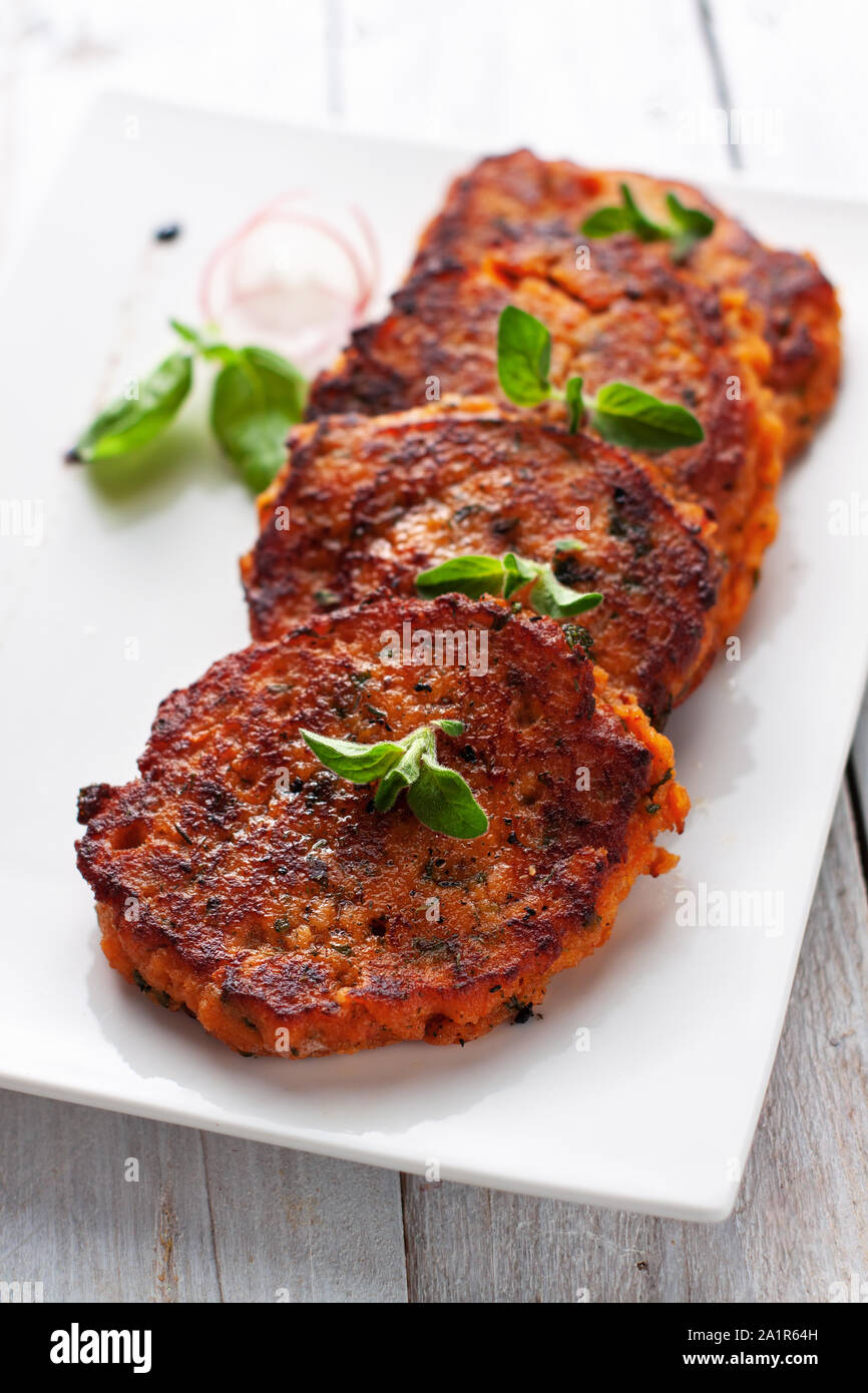 Homemade fried fish patties from canned salmon, sweet potato, eggs and chopped parsley Stock Photo