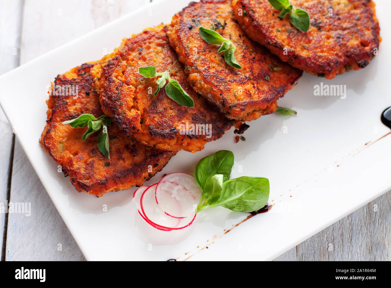 Homemade fried fish patties from canned salmon, sweet potato, eggs and chopped parsley Stock Photo