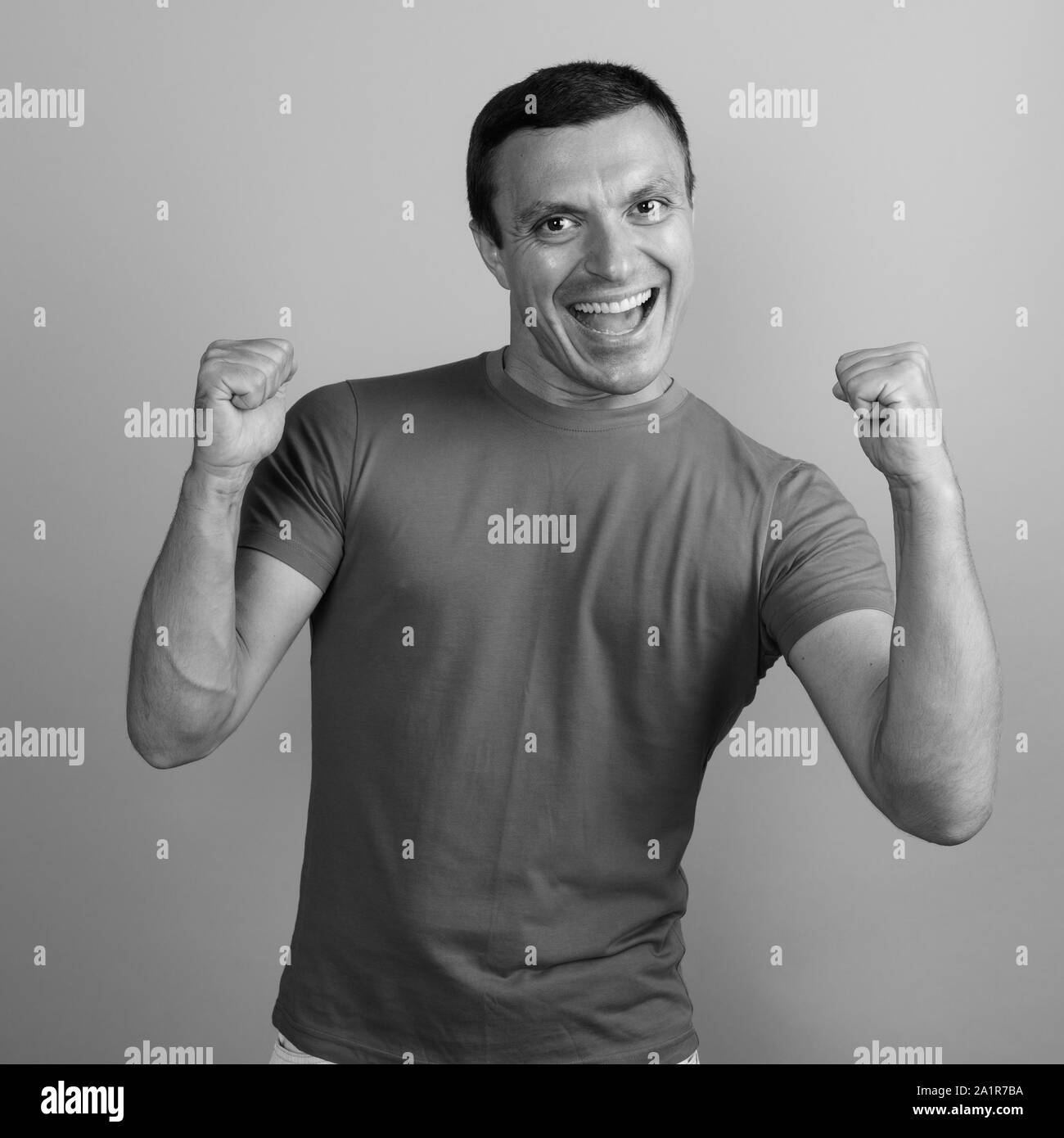 Man wearing t-shirt against gray background shot in black and white Stock Photo