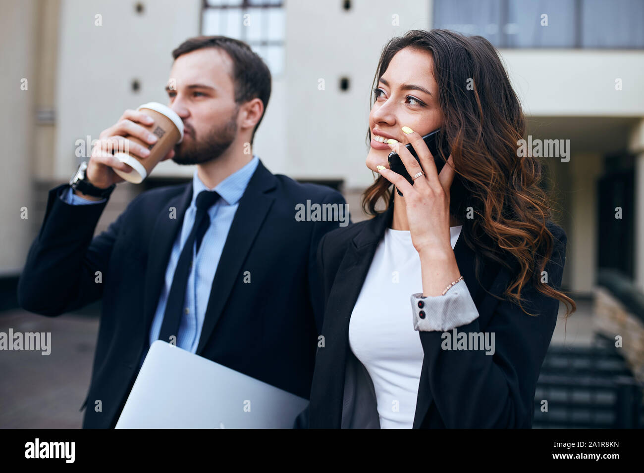 successful young business people talking with smart phone and drinking tea during coffee break. close up side view photo Stock Photo
