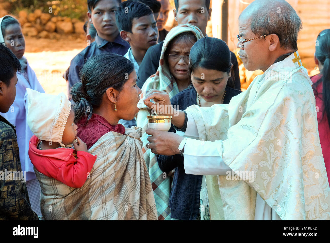 Catholic priest gives Holy Communion, Eucharist during a Catholic