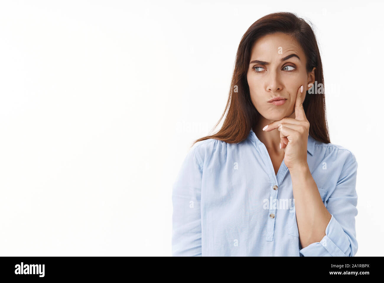 Suspicious brunette middle-aged 30s wife have some thoughts, smirk sly, squinting thoughtful, pondering strange situation, look sideways copyspace Stock Photo