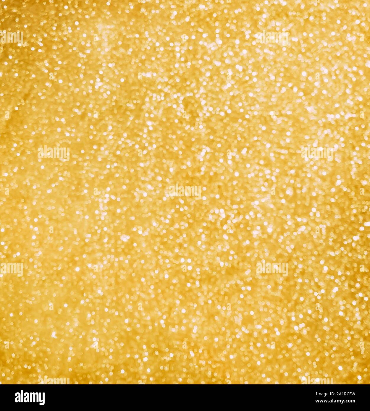 Abstract golden sparkles background. Luxury blured golden texture. The golden surface shines on the light of a thousand lights Stock Photo