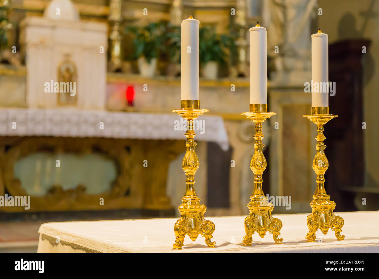 Three golden candelabra lined up on the church altar Stock Photo Alamy