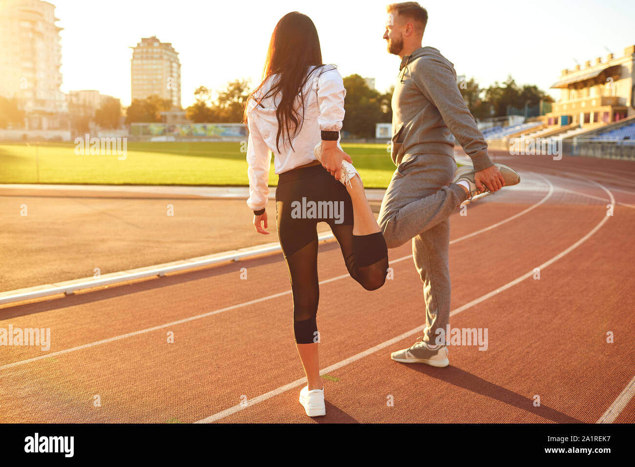 Couple in sportswear doing warm-up at the stadium Stock Photo - Alamy