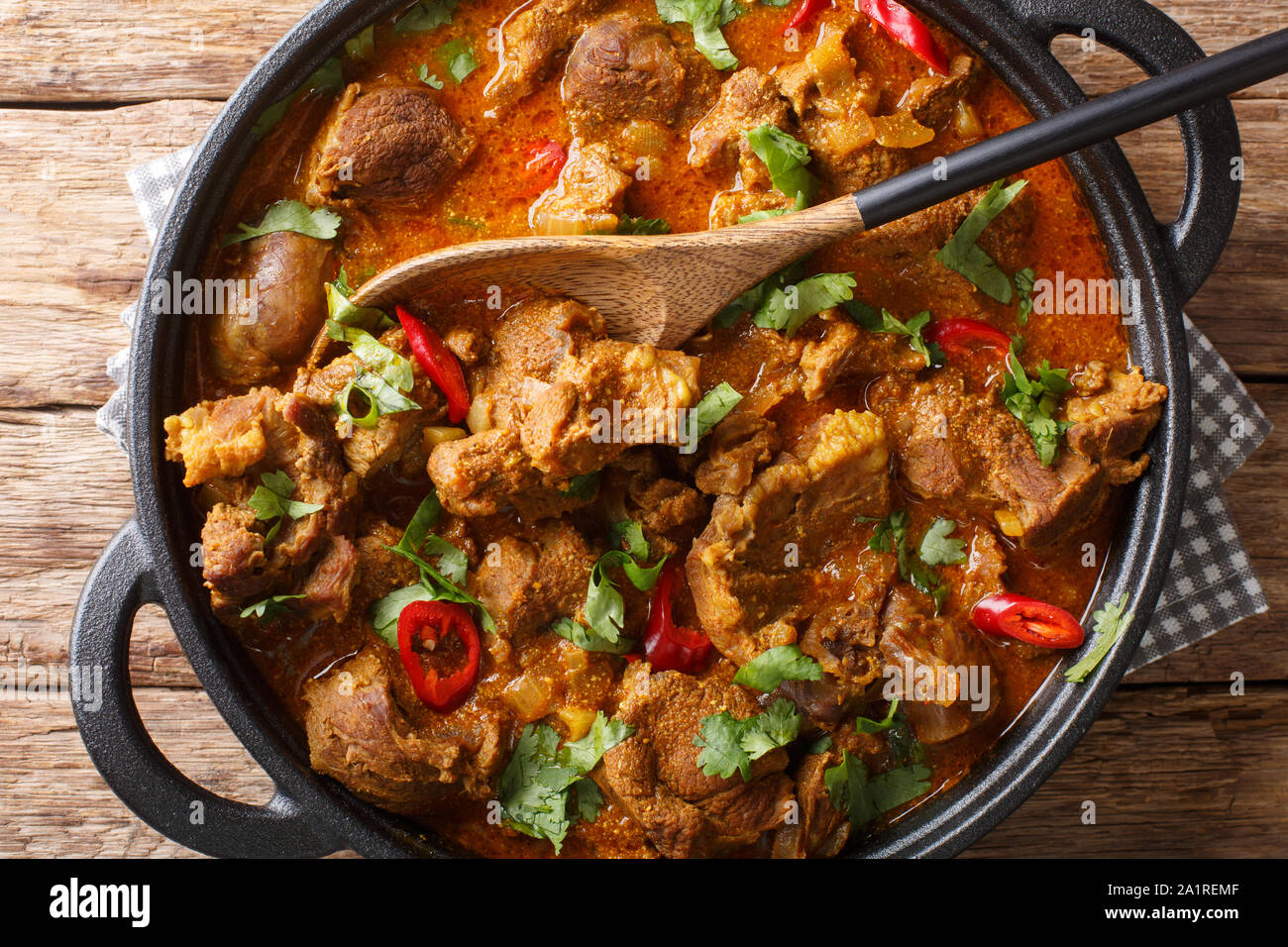 Indian traditional food Lamb rogan josh close-up in a pan on the table. Horizontal top view from above Stock Photo