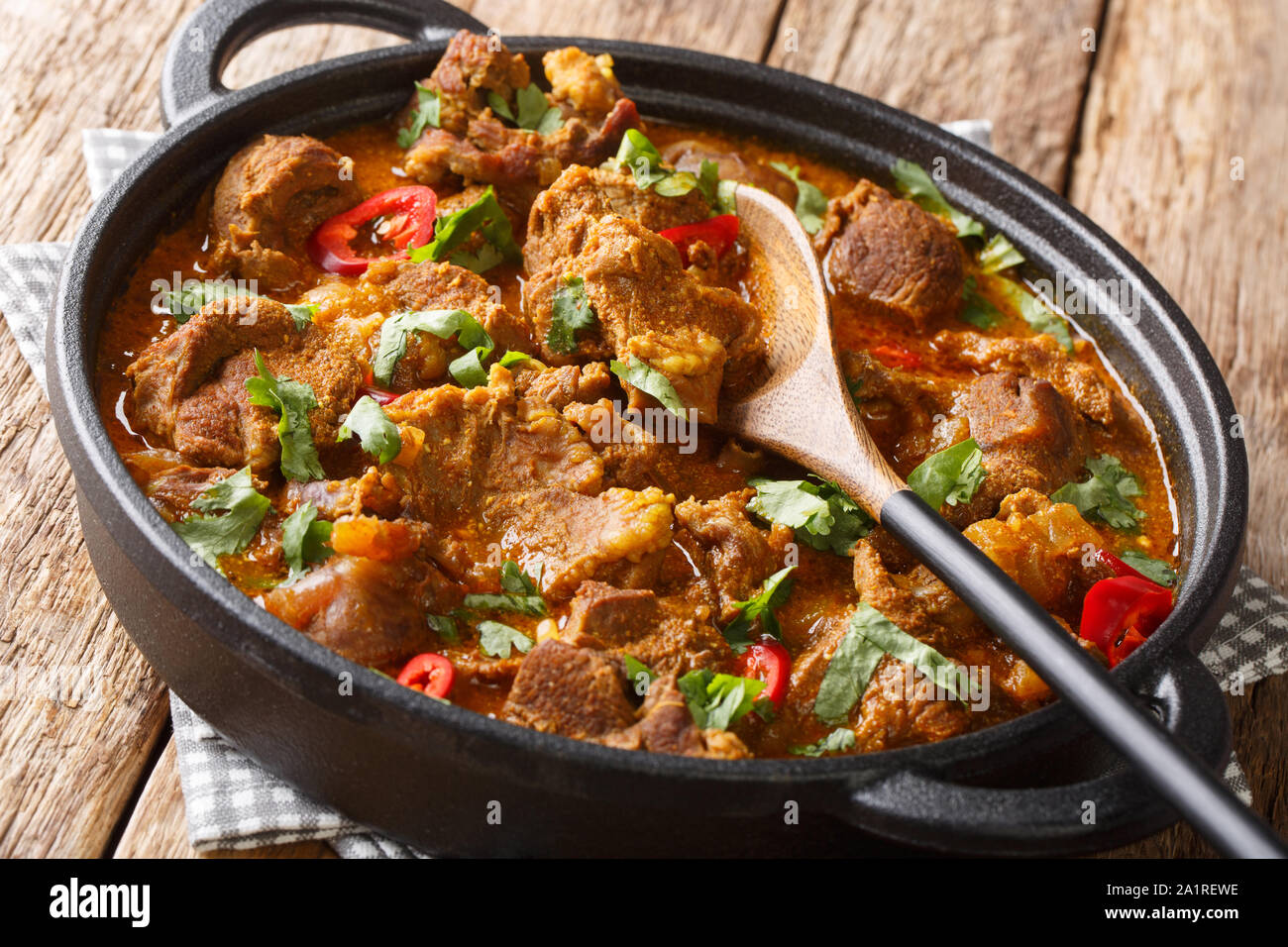 Boneless Lamb slow cooked with yogurt and traditional Indian warm spices closeup in a pan on