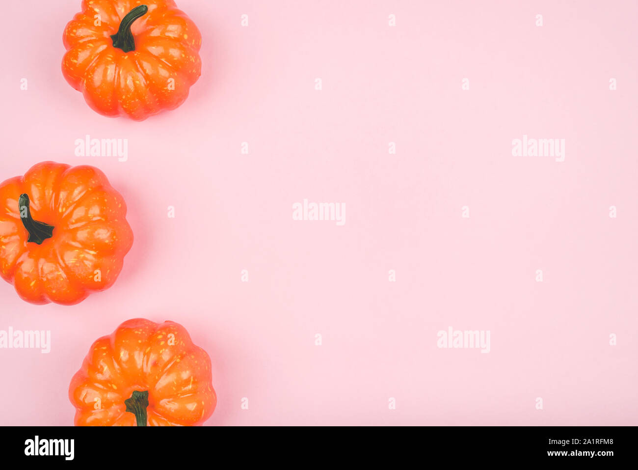 Pink background with three pumpkins. Stock Photo