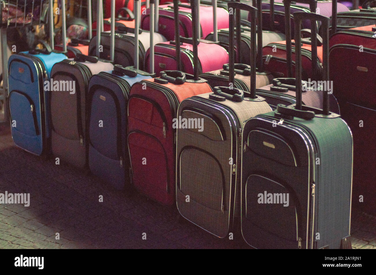 Multicolored suitcases of different sizes in a shop window. Fakes