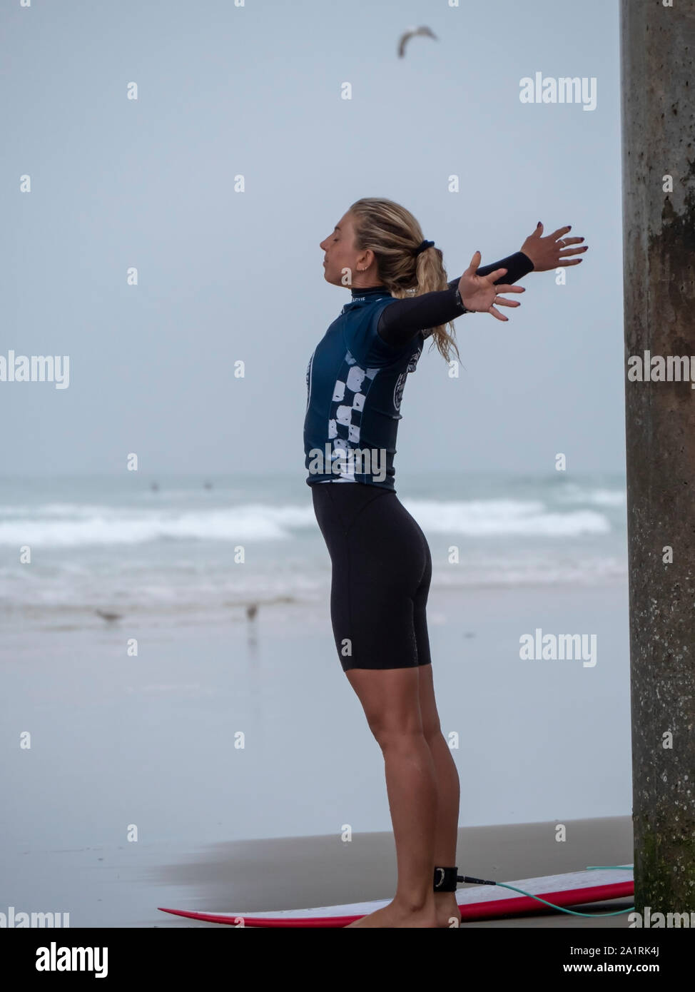 Pro surfer Sage Erricson stretches before the next heat at 2019 US Open of Surfing event Stock Photo