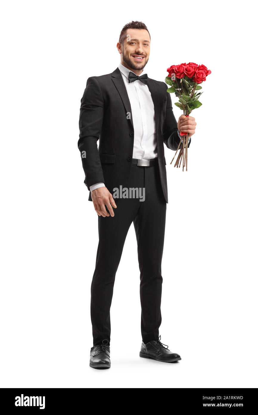 Full length portrait of a man in a suit holding a bunch of red roses ...
