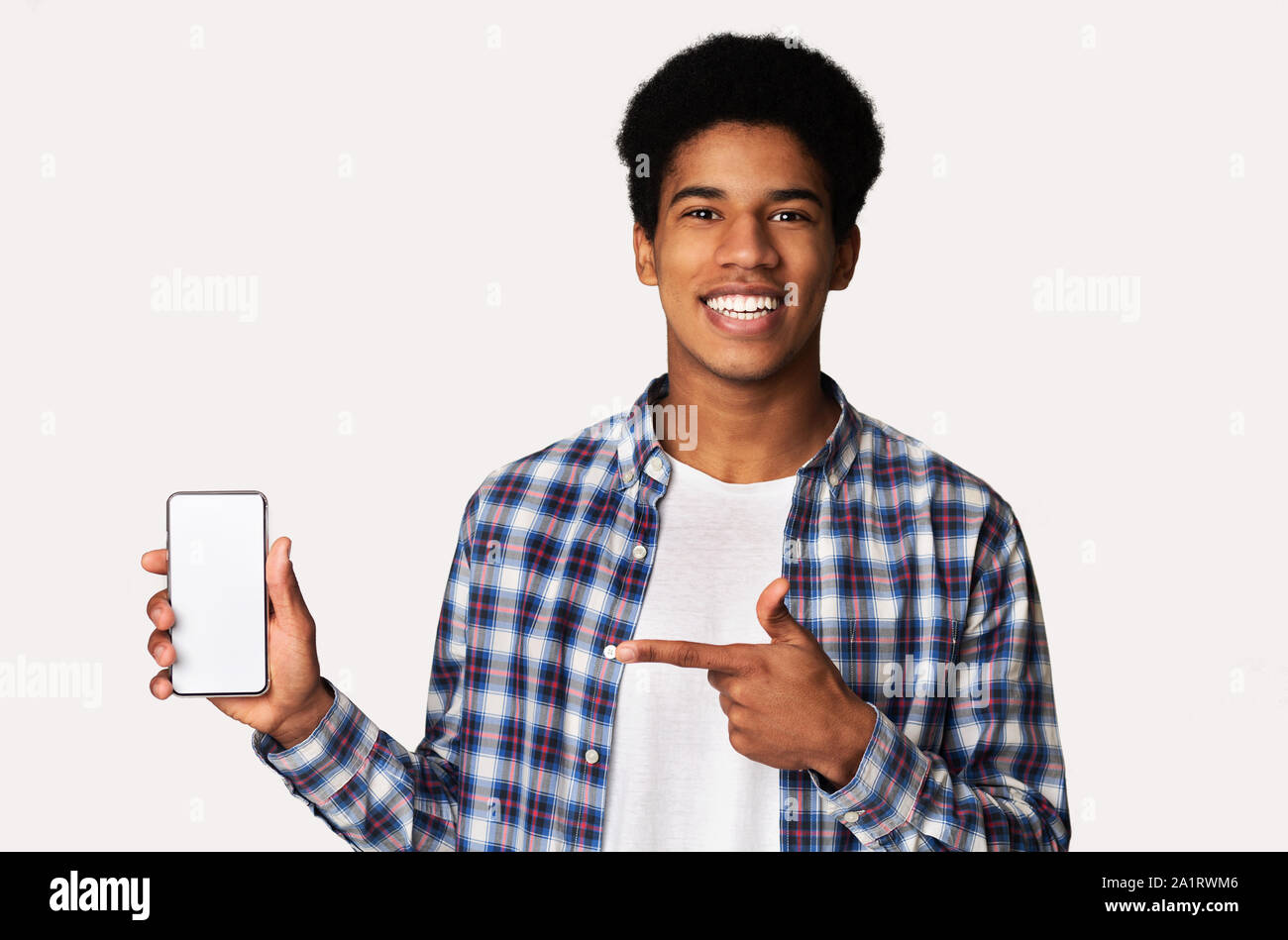 Happy black guy holding smartphone with blank screen Stock Photo - Alamy
