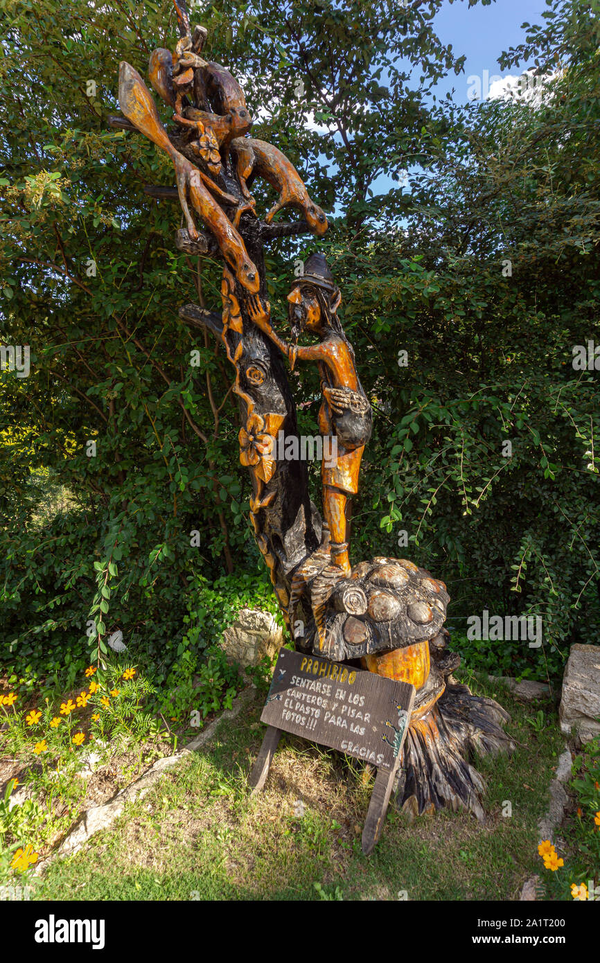 Wooden artcraft sculpture in La Cumbrecita with  sign saying is forbidden sit on it to take photos Stock Photo