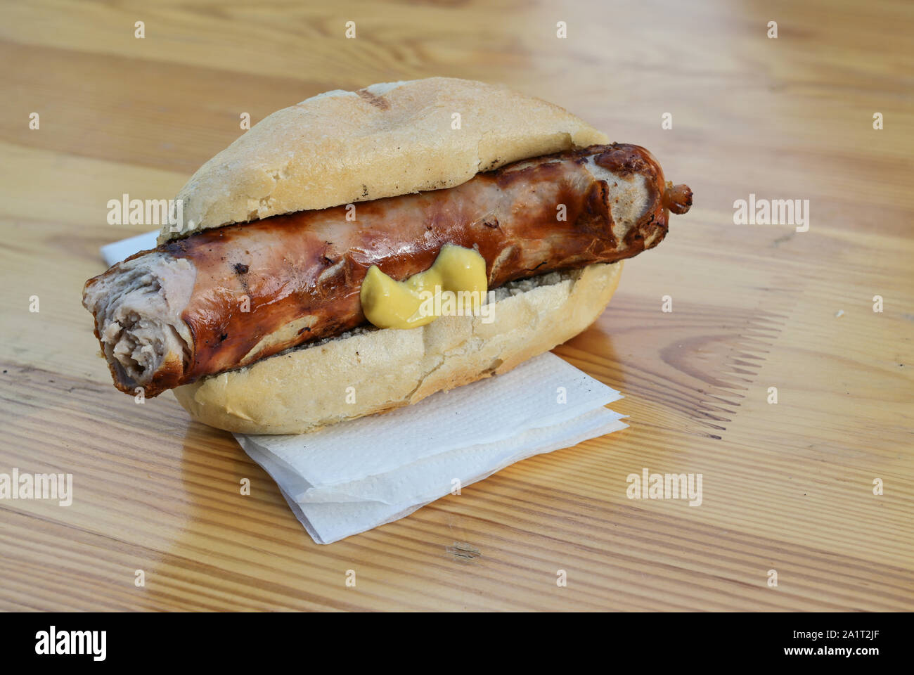 Grilled sausage, in Germany called Bratwurst with mustard in a bun on a