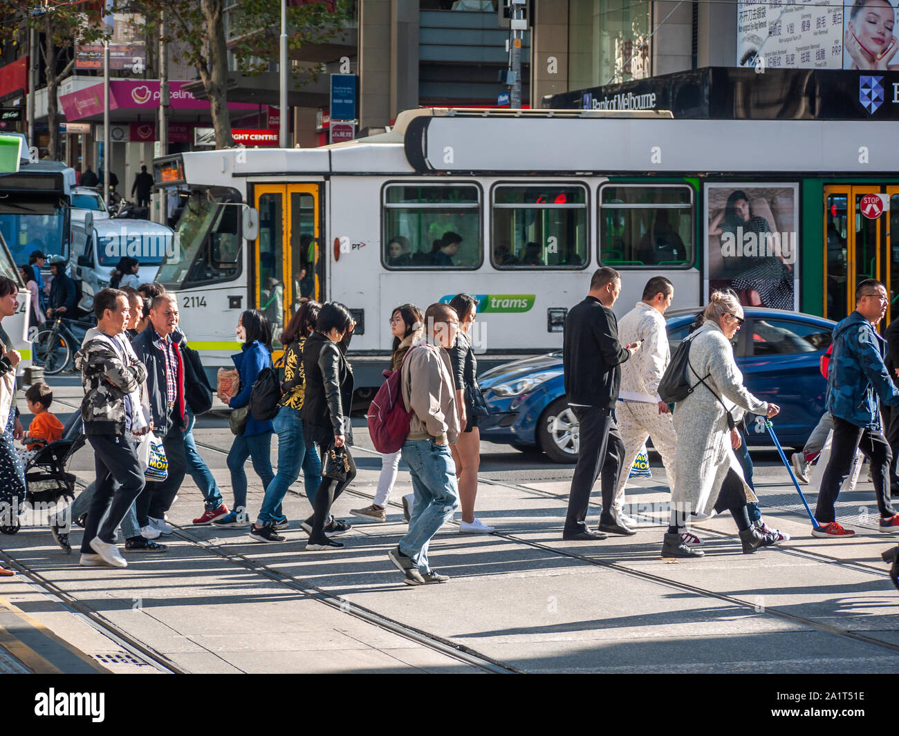 Crowds of pedestrians walking across the street in CBD.  City of Melbourne, VIC Australia. Stock Photo