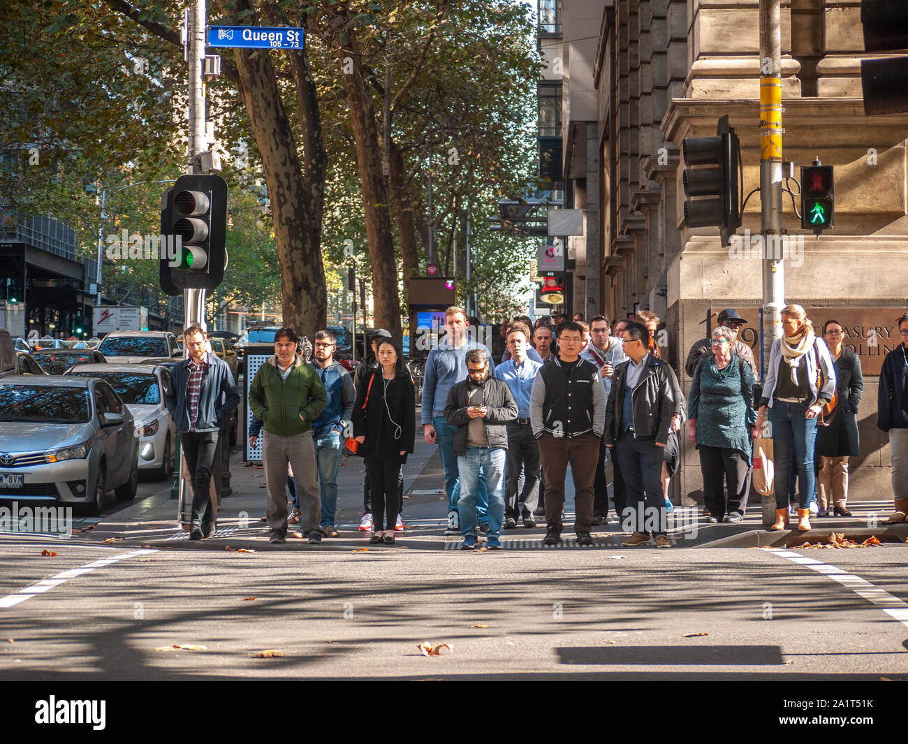 Crowds of pedestrians waiting at the traffic light to cross in CBD. Melbourne, VIC Australia. Stock Photo