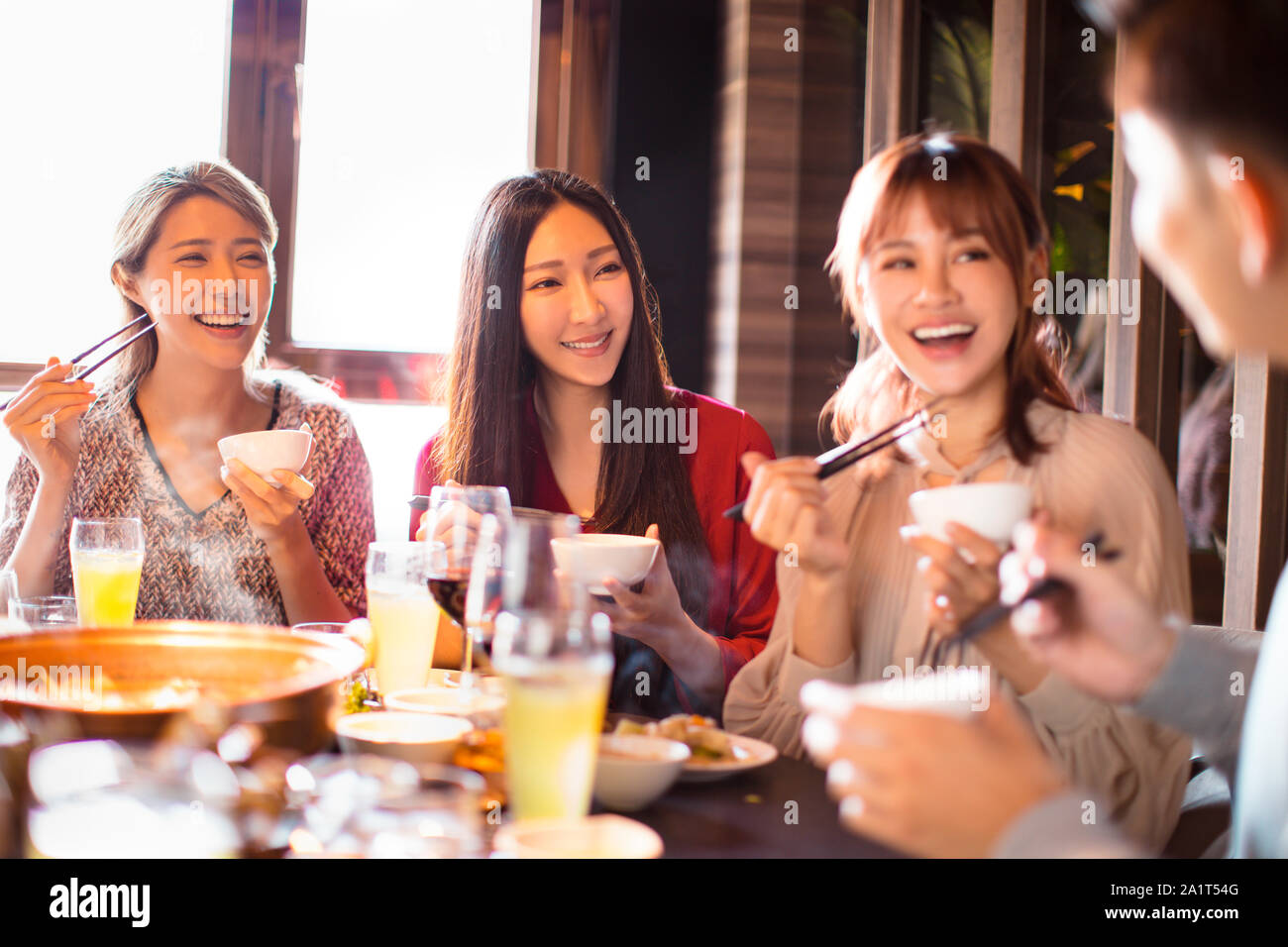 happy young friends enjoy dinner in hot pot restaurant Stock Photo